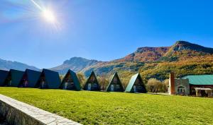 a building in a field with mountains in the background at Mountain View RESORT in Vusanje