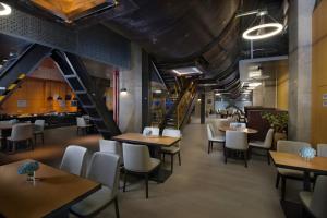 北京市にあるHoliday Inn Express Beijing Shijingshan Lakeview by IHGのテーブルと椅子、階段のあるレストラン