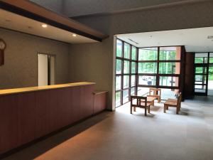 a lobby with a counter and chairs and windows at Aizu Kogen International Human Resources Center - Vacation STAY 44519v in Yasō
