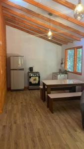 a room with a kitchen with a refrigerator and a table at Cabañas Entrearomos 1 in Panguipulli