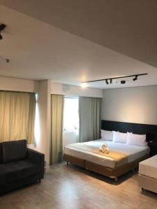 a bedroom with a large bed and a chair at Apartamento lindo com garagem in Sao Paulo