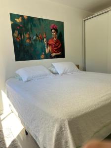 a bedroom with a large bed with a painting on the wall at Top Floripa Apartment in Florianópolis