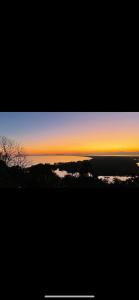 a view of a sunset with the ocean in the background at Minas Em Marambaia in Rio de Janeiro