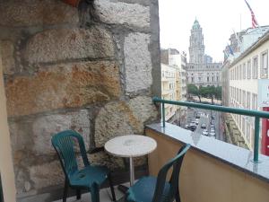 un tavolo e sedie su un balcone con vista sulla città di Hotel Porto Rico a Porto