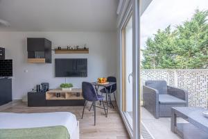 a bedroom with a bed and a table and chairs at Studio entre Paris & Disneyland in Noisy-le-Grand