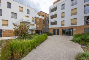 an external view of an apartment building with a driveway at Studio entre Paris & Disneyland in Noisy-le-Grand
