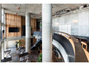 a lobby with a staircase and tables and chairs at Hotel Discover Nagaokakyo - Vacation STAY 29774v in Nagaokakyo