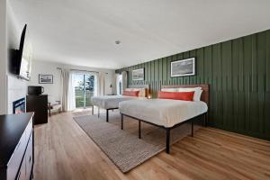 two beds in a room with green walls at Bodega Coast Inn and Suites in Bodega Bay