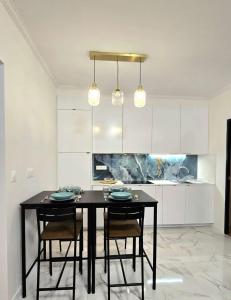 a dining room with a black table and chairs at Temple Marais 1 in Paris