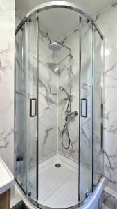 a shower with a glass enclosure in a bathroom at Temple Marais 1 in Paris