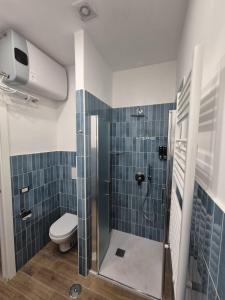 un bagno con wc e doccia con piastrelle blu di La Gioia Napoli a Napoli