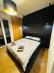 a bedroom with a bed with two towels on it at Apartament Plaza Tower 2 in Kielce