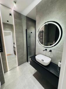 a bathroom with a sink and a mirror at Apartament Plaza Tower 2 in Kielce