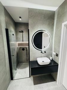 a bathroom with a sink and a mirror at Apartament Plaza Tower 2 in Kielce