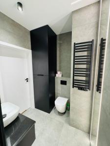 a bathroom with a white toilet and a sink at Apartament Plaza Tower 2 in Kielce