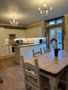 a large kitchen with a wooden table and chairs at The Old Vicarage in Berwick-Upon-Tweed