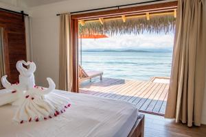 a bedroom with a bed with a view of the ocean at Sol Bungalows Bocas del Toro in Bocas del Toro