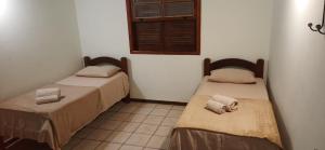duas camas em um quarto com janela em Duplex 450m da Praia do Peró com Enxoval, Wi-Fi, TV a Cabo, Estacionamento em Cabo Frio