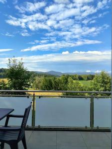 a balcony with a chair and a view of the countryside at Appartement im bayerischen Wald in Untermitterdorf