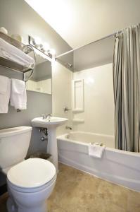 uma casa de banho com um WC, um lavatório e uma banheira em St. Norbert Hotel em Winnipeg