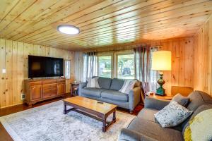 a living room with a couch and a tv at Lakefront Minnesota Escape with Fire Pit and Boat Dock in Emily