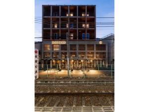 a building with a train tracks in front of it at Hotel Discover Nagaokakyo - Vacation STAY 29764v in Nagaokakyo