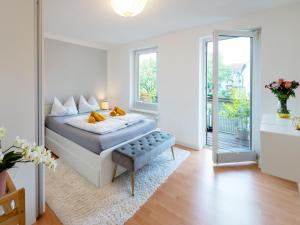 シュヴェリーンにあるSchlosskönig - Modernes & zentrales Apartment mit Balkon und Arbeitsplatzのベッドと鏡のある白い寝室