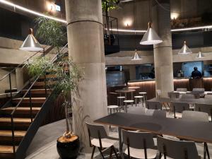 a restaurant with tables and chairs and a staircase at Hotel Discover Nagaokakyo - Vacation STAY 29771v in Nagaokakyo