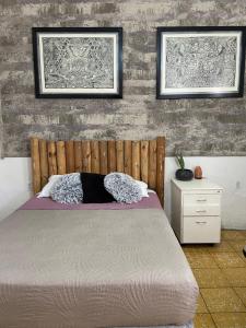 Un dormitorio con una cama y dos cuadros en la pared. en Hostal Centeno, en Guadalajara
