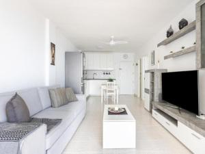 a white living room with a couch and a tv at Live Candelaria Tamonante in Candelaria