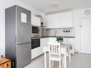 a white kitchen with a table and a refrigerator at Live Candelaria Tamonante in Candelaria
