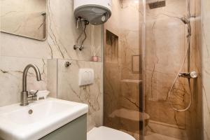 Un baño con ducha, lavabo e inodoro. en Tiny studio in center of Varna, en Varna