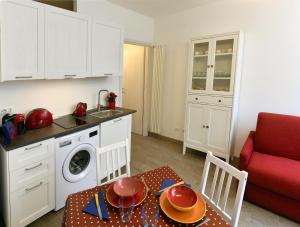 a small kitchen with a table and a red couch at Il Gioiello del Conte in Turin