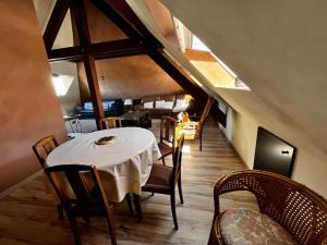 a dining room with a white table and chairs at Au Coin du Feu in Lembach