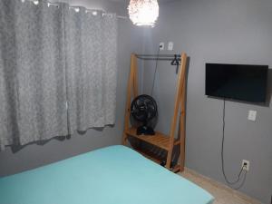 a bedroom with a bed and a flat screen tv at Verde Mar Abricó 2 in Rio das Ostras +8 photos