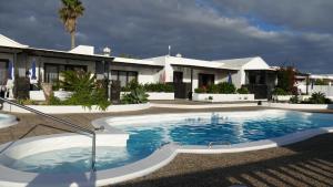 a swimming pool in front of a house at Finca del Mar Naturist Complex in Charco del Palo