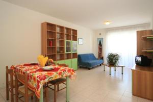 a living room with a table and a blue couch at Residence Cristoforo Colombo in Caorle