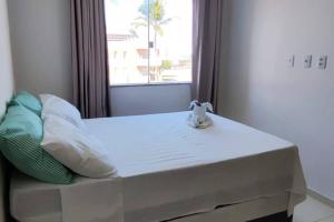 a bed in a room with a window at Apto em Ilhéus - Pé na areia in Ilhéus
