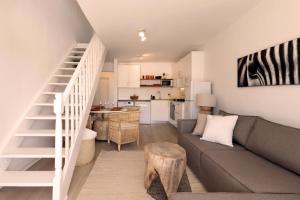 a living room with a couch and a kitchen at Four Peaks Duplex - 4 Sleeper with Mountain Views, Balcony and Pool in Hout Bay Beachfront in Hout Bay