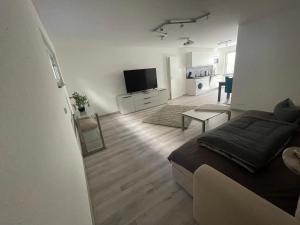 a living room with a bed and a flat screen tv at Moderne Souterrain Wohnung in zentraler Lage in Filderstadt