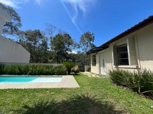 una casa con giardino e piscina di Casa 09 Floresta Boa Vista - Piscina Privativa, Jardim e Lazer Completo a Teresópolis