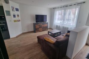 a living room with a couch and a flat screen tv at Maison familiale 6 pers ,1 bébé in Étaples