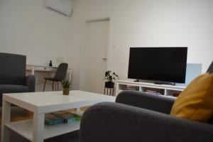 a living room with two chairs and a tv at Dunakorzo Apartman in Szentendre