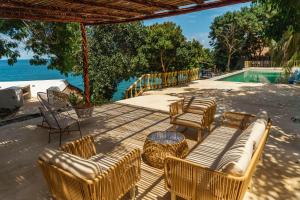 a patio with chairs and a table and a pool at Casa Kaimari By SoHo in Cartagena de Indias