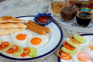 a plate of eggs and bread and some drinks at Haad Somboon House in Bang Saphan
