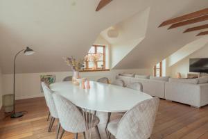 Un comedor blanco con una mesa y sillas blancas. en Penthouse Downtown with 4 bedrooms and Harbour View, en Tórshavn
