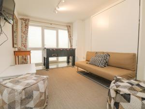 a living room with a couch and a piano at Ridgeback House in Helston
