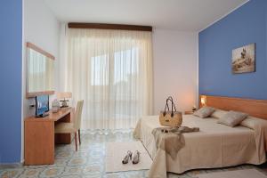 Un dormitorio con una cama y un escritorio con una computadora. en Raffy Family & Bike Hotel, en Diano Marina 27 fotos más