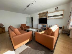 een woonkamer met twee banken en een flatscreen-tv bij Ferienwohnung Zobl in Füssen