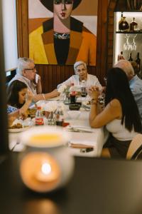 Eine Gruppe von Menschen sitzt um einen Tisch und isst. in der Unterkunft Manakin Hostal & Resto in Manta